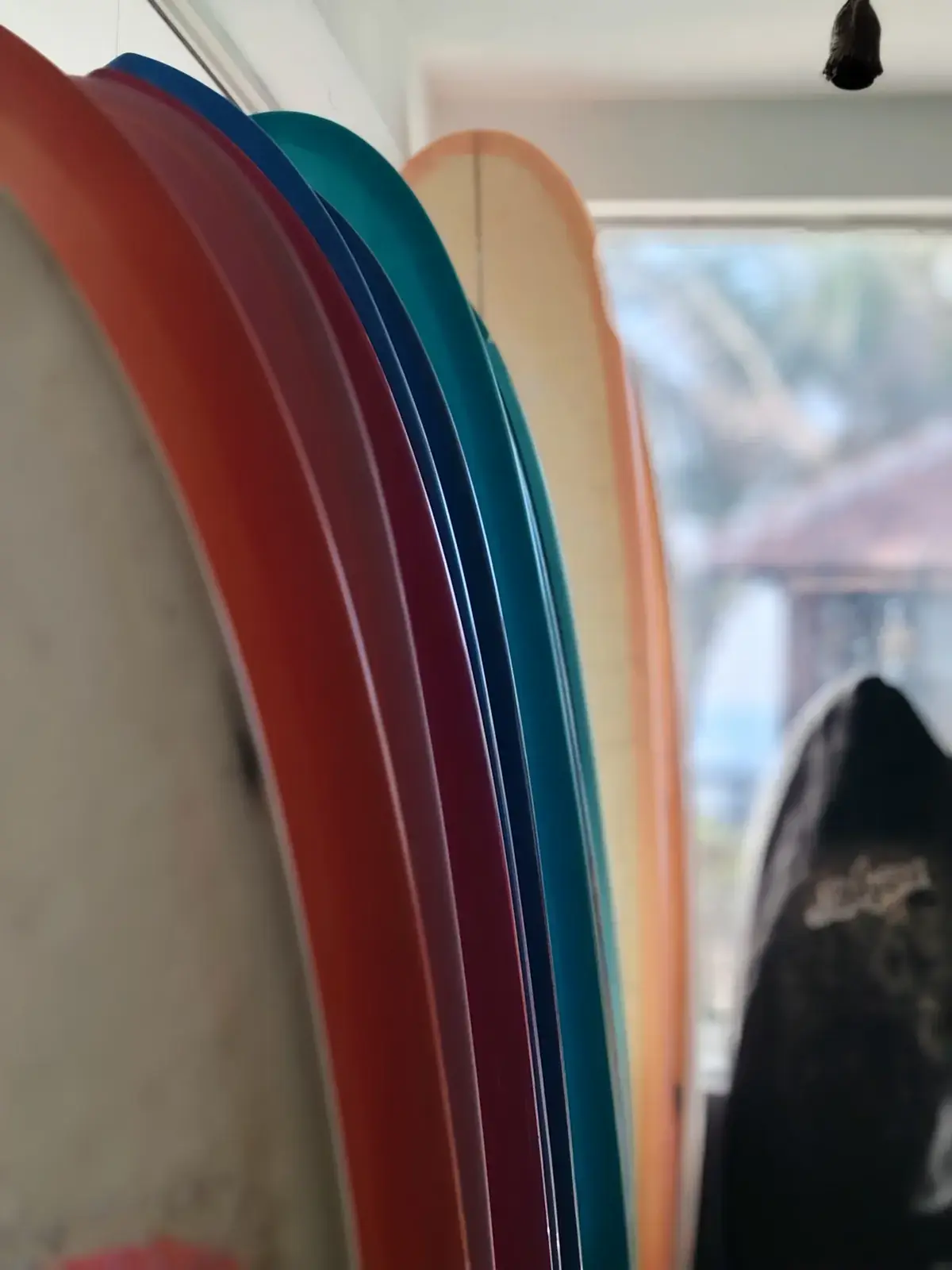 Close-up of colourful surfboards in a rack