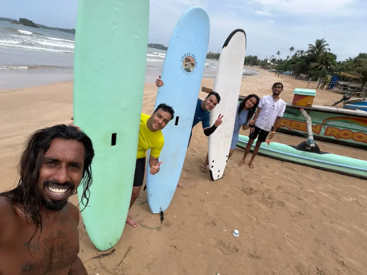 Instructor’s selfie with a group and their boards on the beach