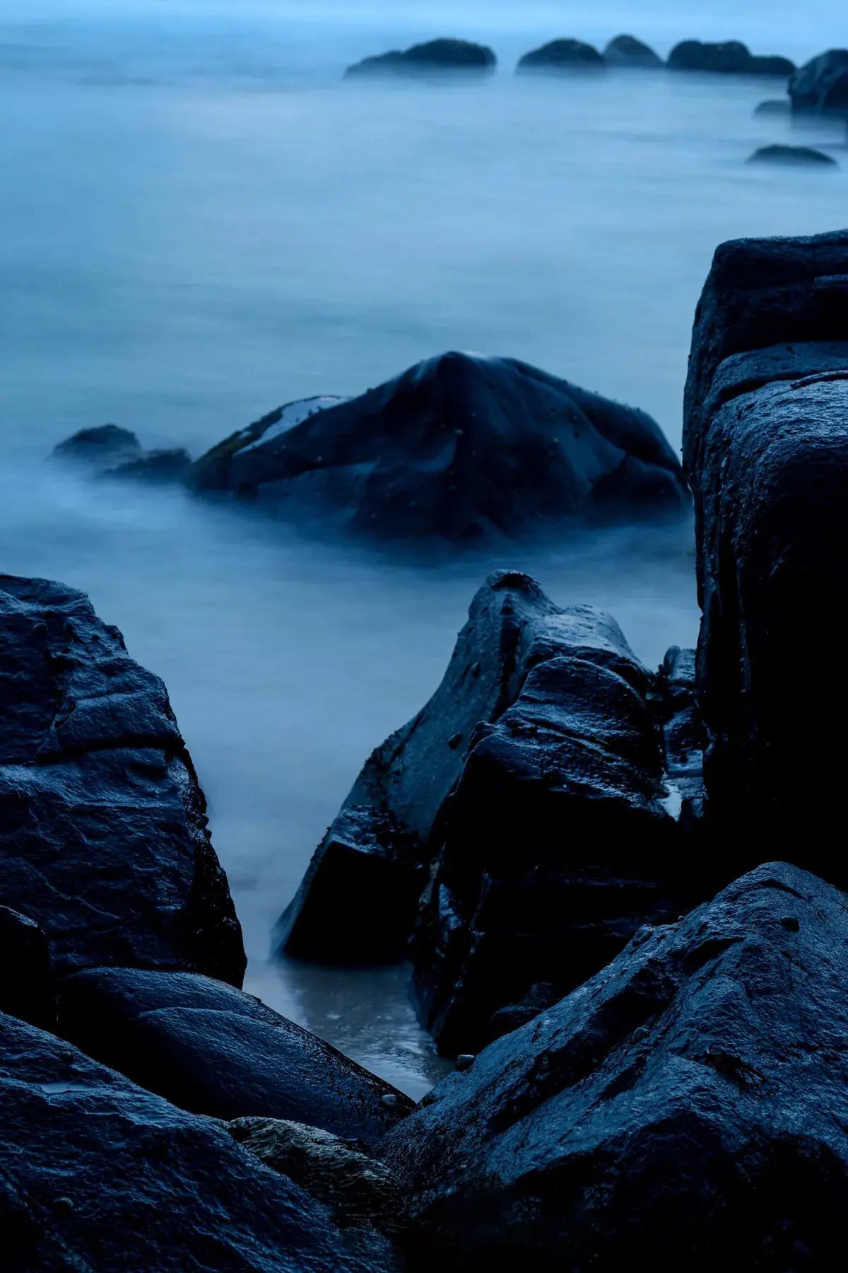 Dark rocks at the water’s edge in Madiha